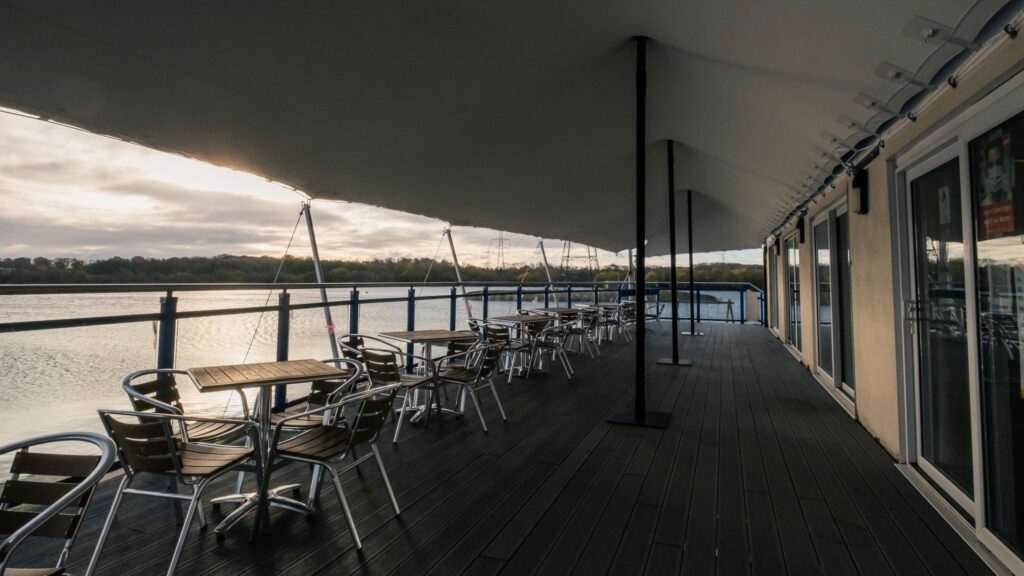 Permanently installed stretch canopy over an outdoor bar and seating