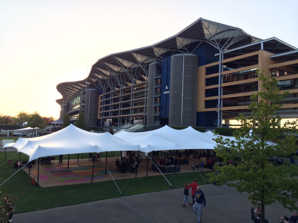 Peaked white stretch tent set for corporate hospitality beside a stadium
