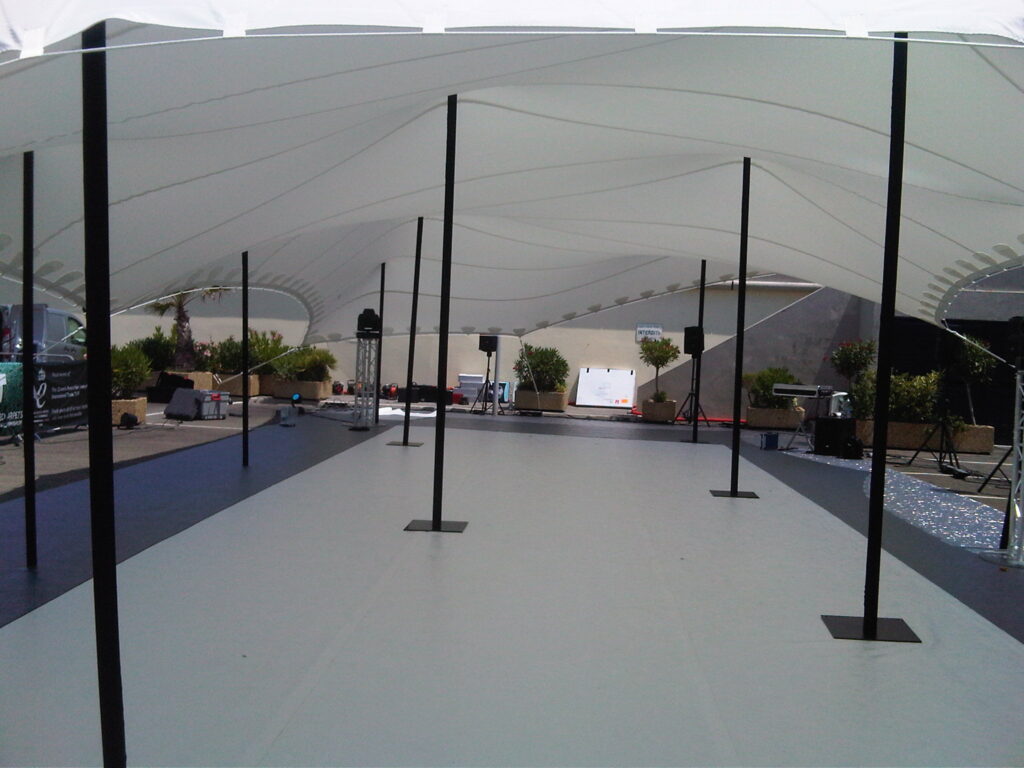 Stage and sound equipment set up beneath an open-sided stretch tent