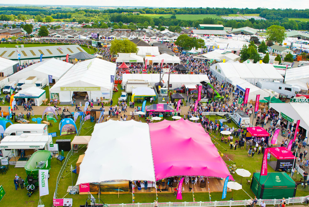 A large stretch tent pitched for a festival build in central London parkland