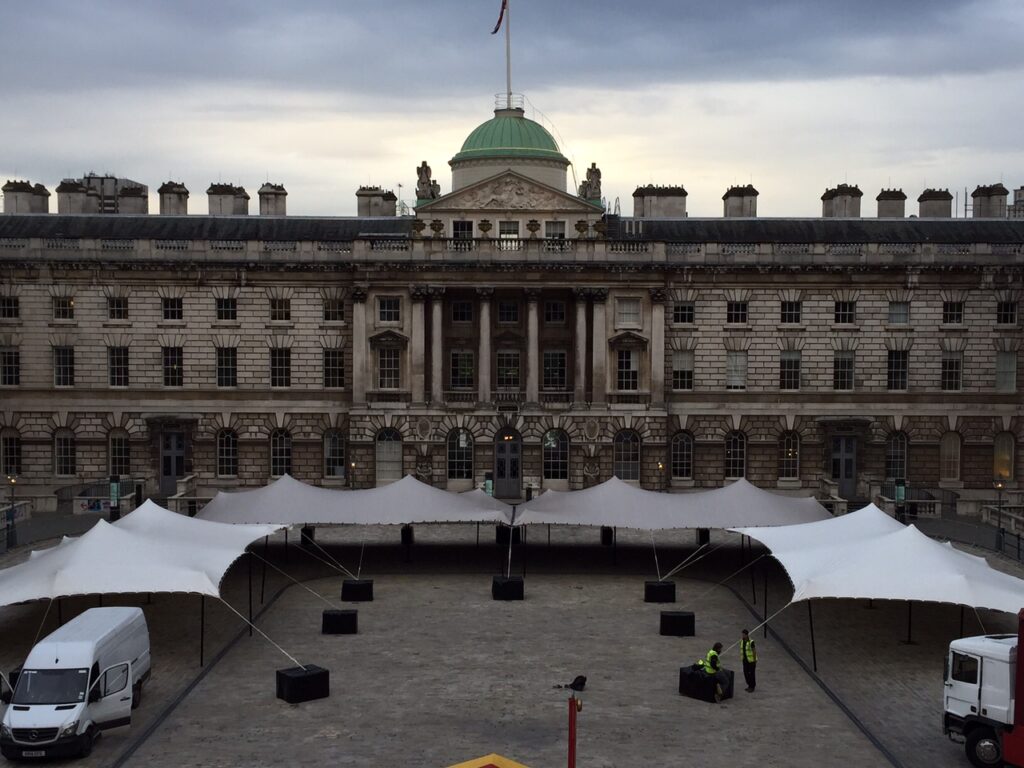 Linked stretch tents during installation in a historic courtyard