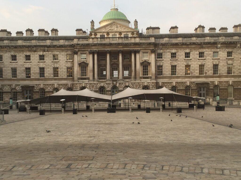 Stretch tents installed across a historic stone courtyard